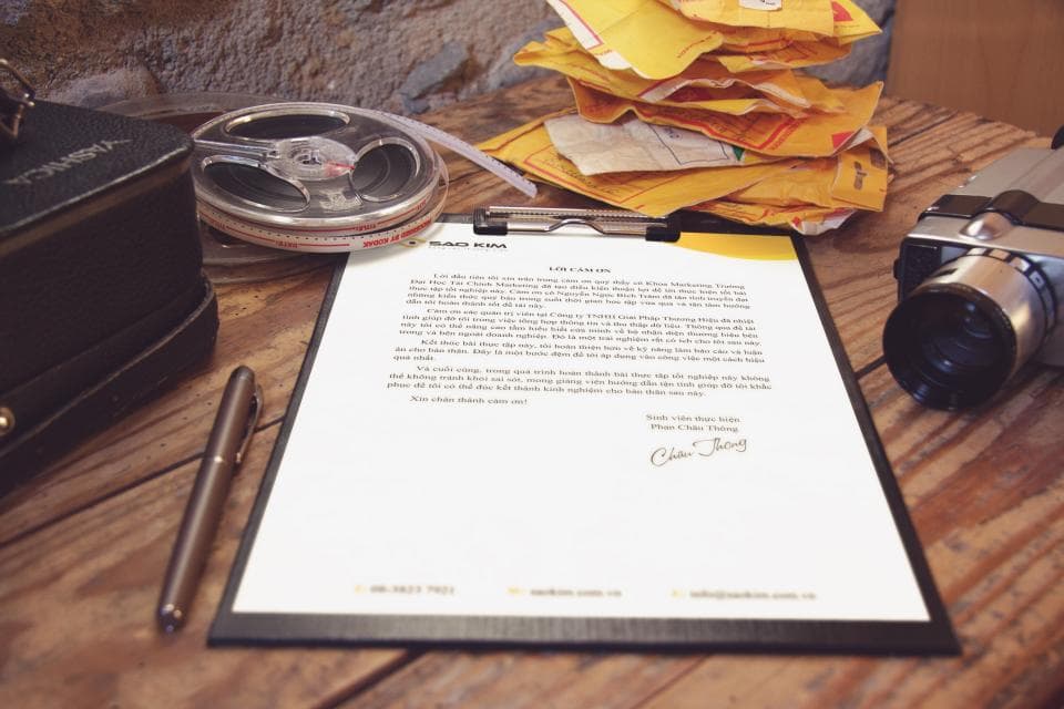 A document and a pen on a wooden desk.