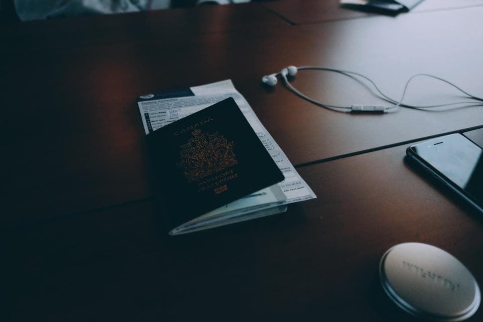 A passport and a notebook on a dark desk.